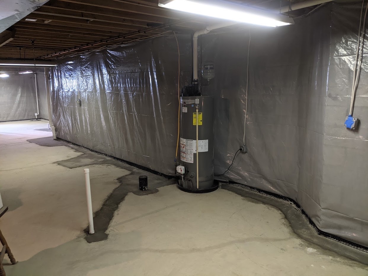 Completed vapor barrier and interior drainage system in Maryland basement