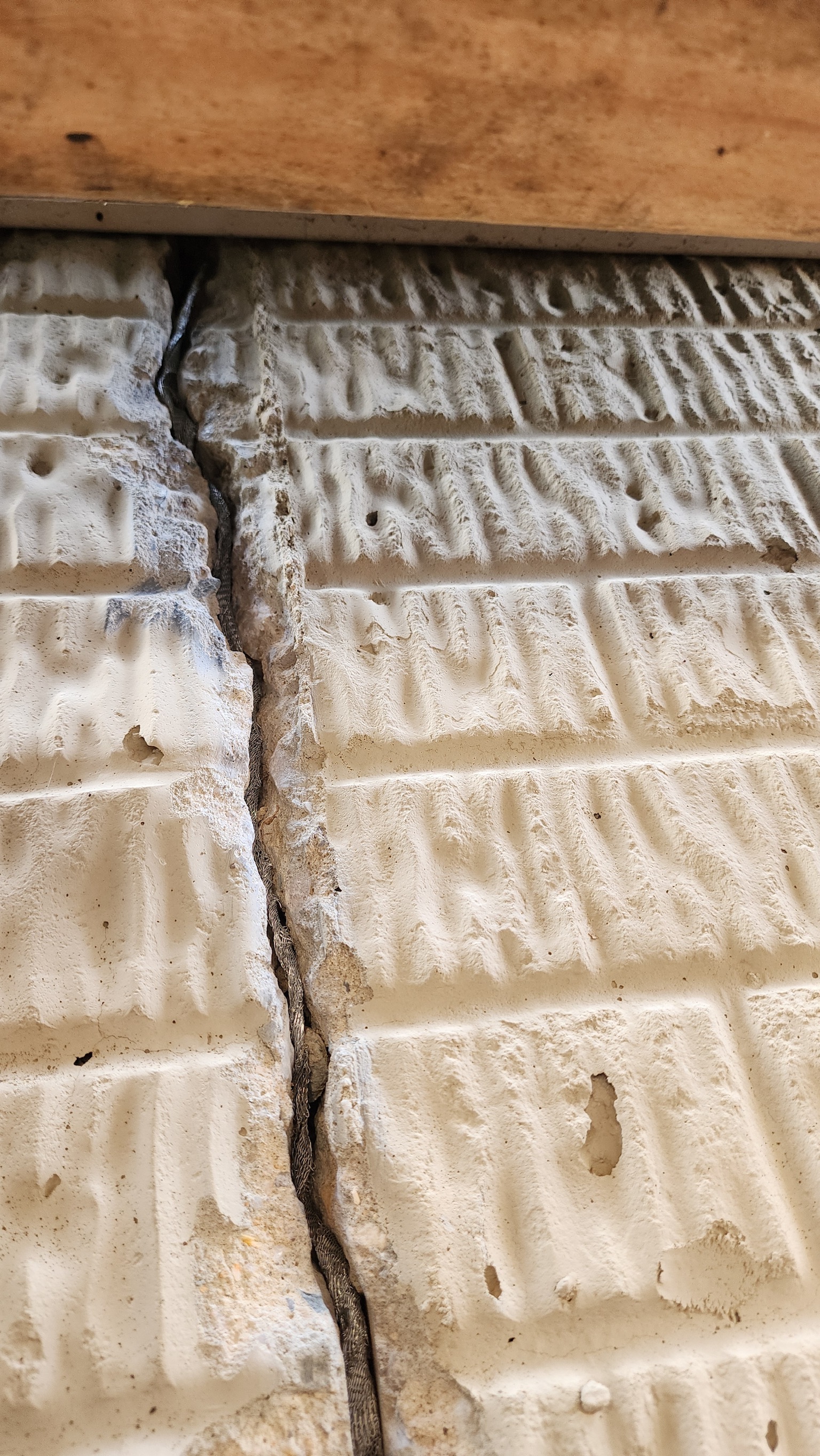 Prominent vertical crack in block foundation indicating differential settlement