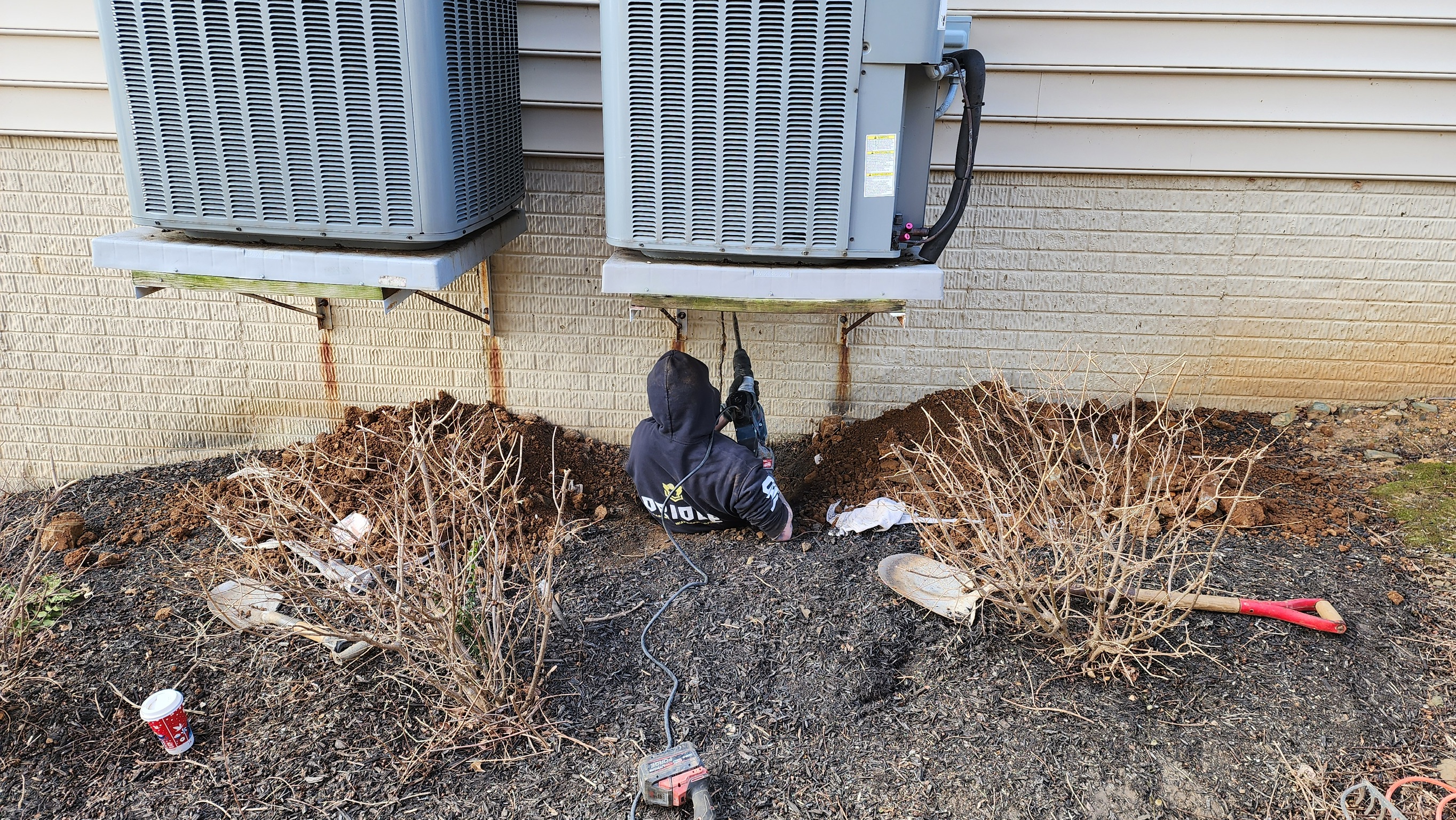 OBW technician performing structural assessment — drilling into block foundation